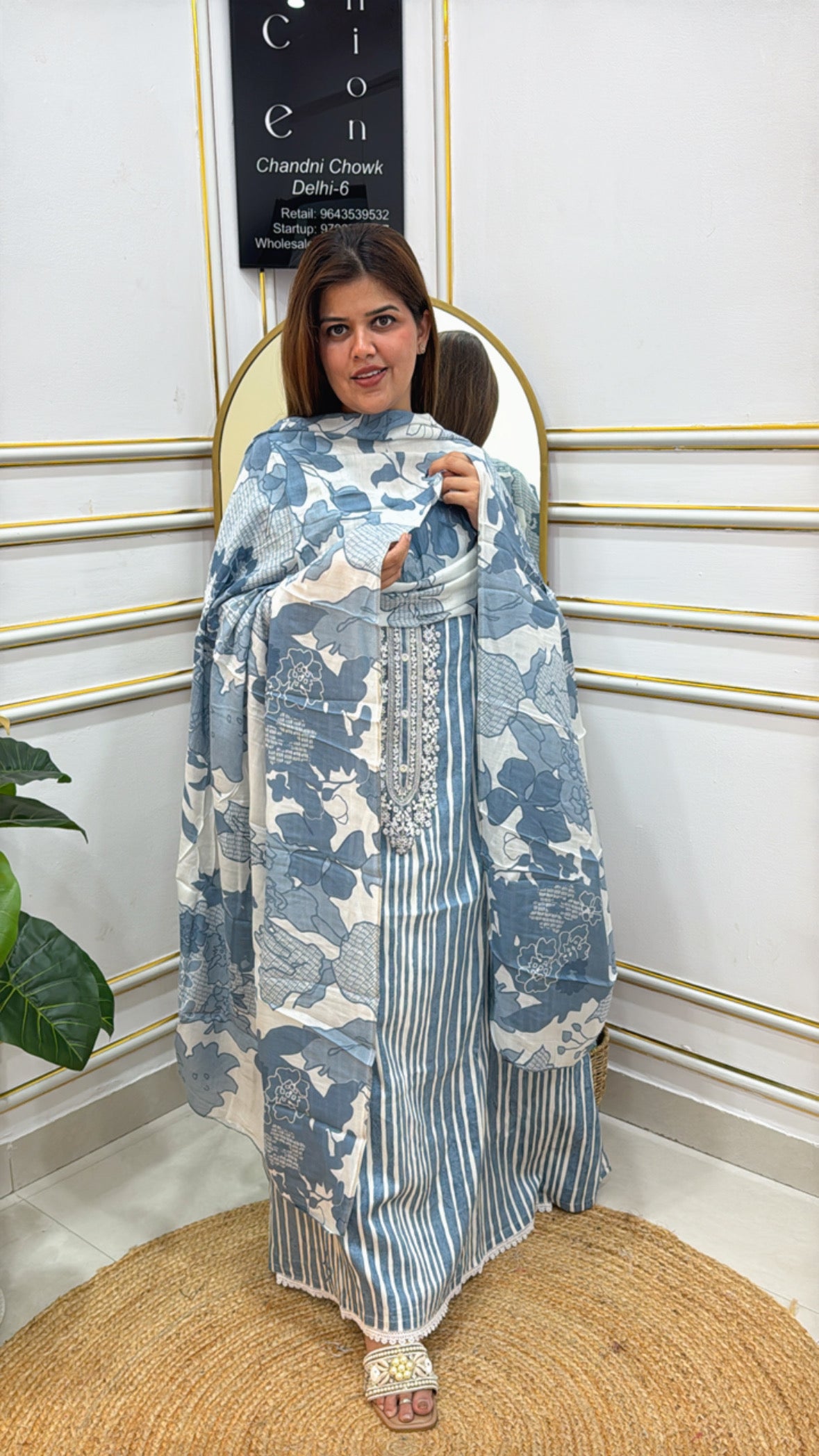 Elegant woman showcasing premium embroidered cotton suits in blue floral design with matching dupatta